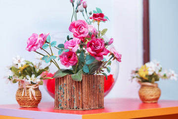 Wooden Flower pots and red gold roses . Beautiful pink ranunculus wooden plant in pot on white background
