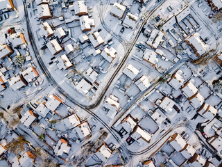 Aerial view of snow covered traditional housing suburbs in England. Snow, ice and adverse weather conditions bring things to a stand still in the housing estates of a British suburb