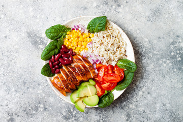 Homemade Mexican chicken burrito bowl with rice, beans, corn, tomato, avocado, spinach. Taco salad lunch bowl © sveta_zarzamora
