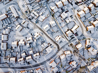 Aerial view of snow covered traditional housing suburbs in England. Snow, ice and adverse weather conditions bring things to a stand still in the housing estates of a British suburb