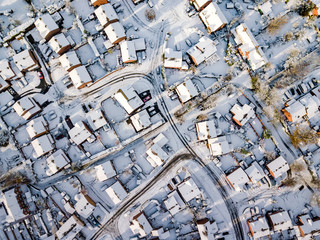Aerial view of snow covered traditional housing suburbs in England. Snow, ice and adverse weather conditions bring things to a stand still in the housing estates of a British suburb