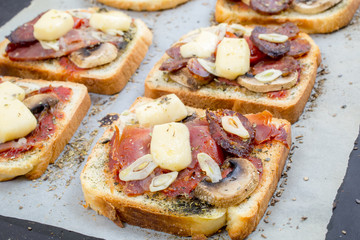 Toasts with ham, cheese and mushrooms on a white background