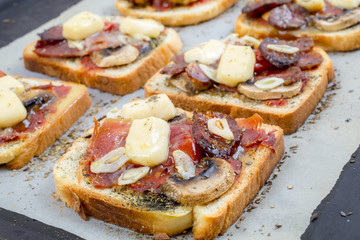 Toasts with ham, cheese and mushrooms on a white background