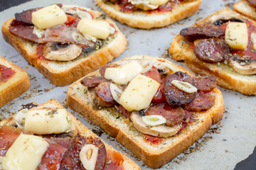 Toasts with ham, cheese and mushrooms on a white background