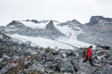 Fototapeta premium Hiker above Snowbird Glacier in Hatcher Pass area of Alaska, summer 2017.