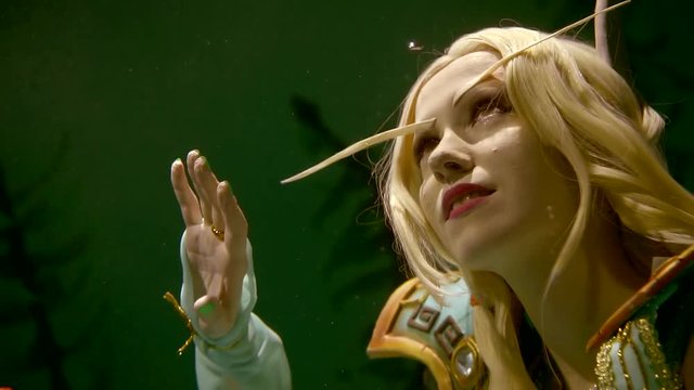 Close up shot of a beautiful blonde girl elf living in water. Interesting clothes, fantastic look.
