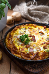 Baked omelette with bacon and cheese in a pan, close view