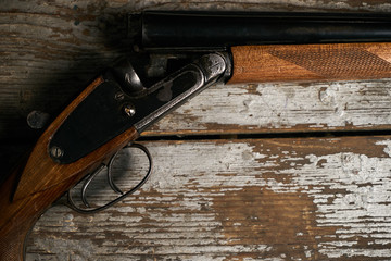 Hunting shotgun riffle on old rustic wooden table