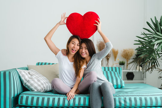 Beautiful young asian women LGBT lesbian happy couple sitting on sofa hugging and smiling together in living room at home. LGBT lesbian couple together indoors concept. Spending nice time at home.