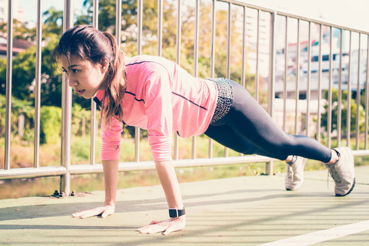 Fitness sport girl fashion sportswear doing yoga fitness exercise in street. Fit young asian woman doing training workout in morning. Young happy asian woman stretching at park after running workout.