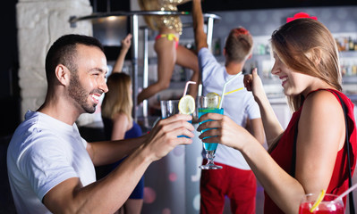 Female and male clubbing with cocktail in the club on party