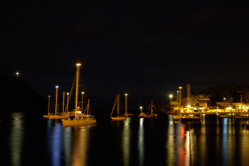 Fototapeta na wymiar Boats swinging on the sea. Blurred mast. Night on the boats in bay.
