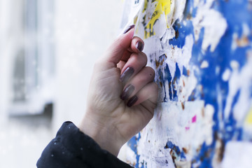 The girl tears off the ad on the Board. Winter. Cold. Job search.