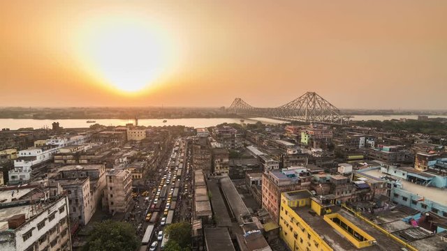 4K Timelapse of a beautiful sunset over Kolkata city with a Howrah bridge on the Ganga river, West Bengal, India.