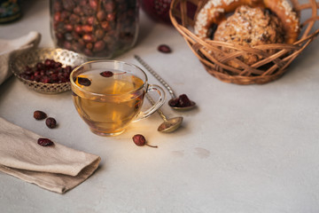 Obraz na płótnie Canvas Hot herbal tea with a dogrose in a glass cup.