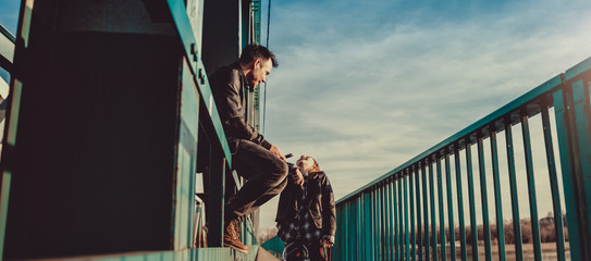 Father and daughter on the bridge talking and smiling