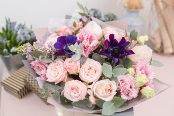 beautiful luxury bouquet of mixed flowers on pink table. the work of the florist at a flower shop.