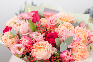 beautiful luxury bouquet of mixed flowers on pink table. the work of the florist at a flower shop.