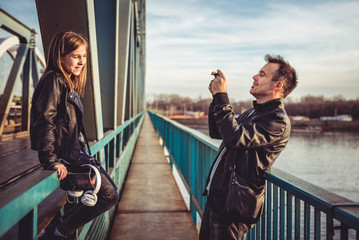 Father and daughter taking photos on the bridge