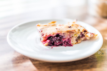 Closeup of hot red cherry cobbler banana bread piece slice cake on plate, golden crust, macro detail texture