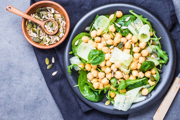 Light fresh chickpea salad with greens and seeds top view text space.