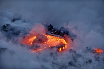 The hot lava of the Hawaiian volcano Kilauea flows into the waters of the Pacific Ocean