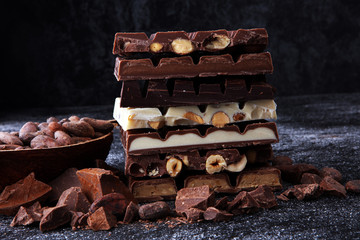 Chocolate bars on dark background with chocolate tower