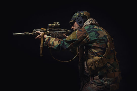 soldier of the American special forces in Afghanistan poses with a rifle on a black background