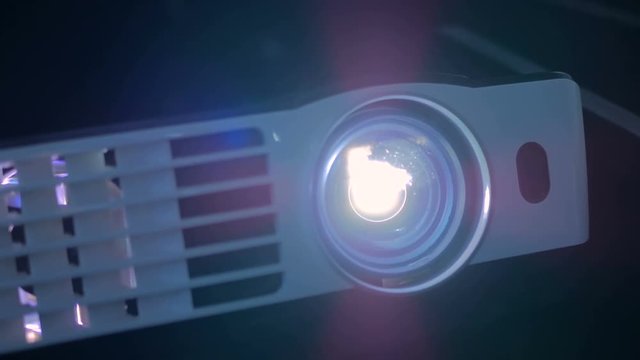 Front view of digital film projector, lens flare. Cinema and entertainment concept