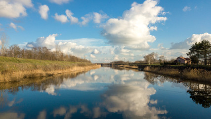 Beautiful drone shot of a river with cloudy sky reflecting in the water