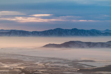Interesting looking snow covered mountains of Utah in the afternoon just after a blizzard. The light coming into the plane window created an interesting array of colors. 