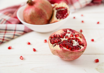 pomegranate with seeds,red tablecloth.white wooden table.