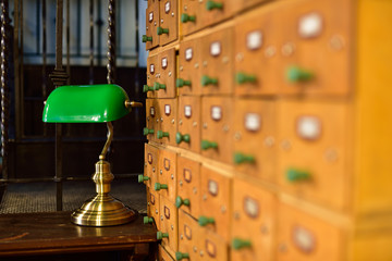 A library file with a desk and a lamp in the background.