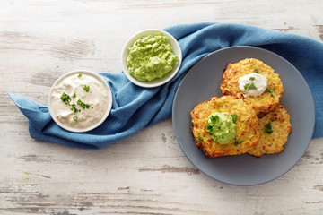 vegetable rosti from cauliflower and parmesan with two dips from sour cream and avocado, parsley...