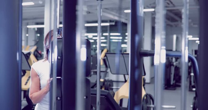 Adult woman doing Exercises for Tricep in fitness gym. Beautiful Woman doing triceps workout. Fitness girl doing triceps cable pushdown exercise in gym