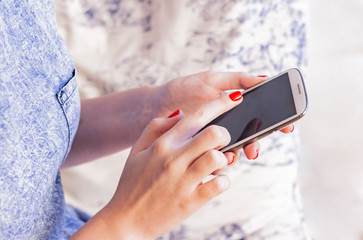 Woman at home relaxing reading on the smartphone 
