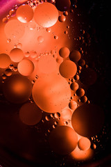 Abstract macro oil in water. I made this using a high powered falshlight and orange food coloring. That way there are hard shadows and bright circles to create a a unique look.