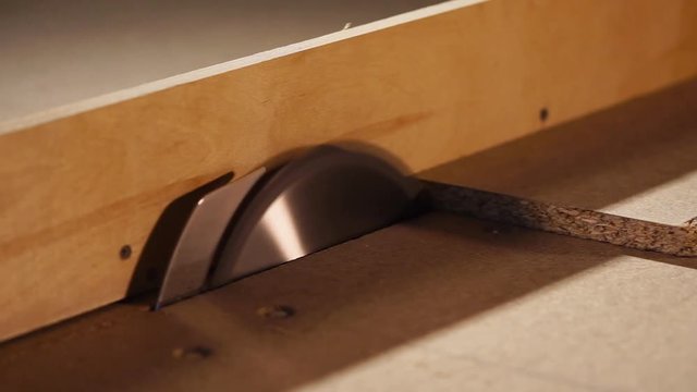 close up shot of a construction electric saw that cuts a board from the chipboard into two halves, the worker creates furniture in a carpentry workshop