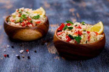 Tabbouleh salad with couscous on the plate.Traditional middle eastern or arab dish.Vegetarian.Parsley,pepper,cucumber,tomato,lemon.Middle eastern meze.Food or Healthy diet concept.Copy space for Text.