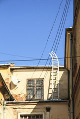 Fototapeta na wymiar Ladder on the sky. Old house in Lviv, Ukraine.