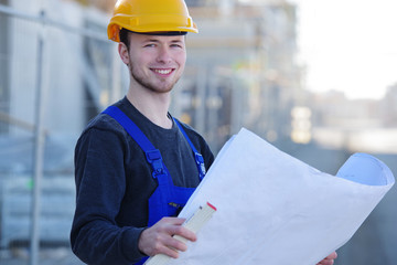 Bauarbeiter mit Bau-Zeichnungen auf einer Baustelle 