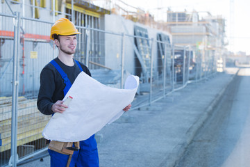 Bauarbeiter mit Bau-Zeichnungen auf einer Baustelle 