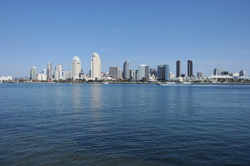 Fototapeta premium San Diego Skyline at noon from Coronado Island. San Diego at noon with Coronado Bay in Foreground and speeding boat.