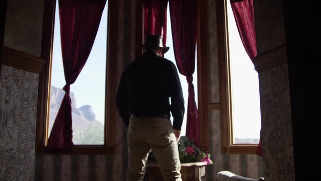 Old west town bordello cowboy walks into frame