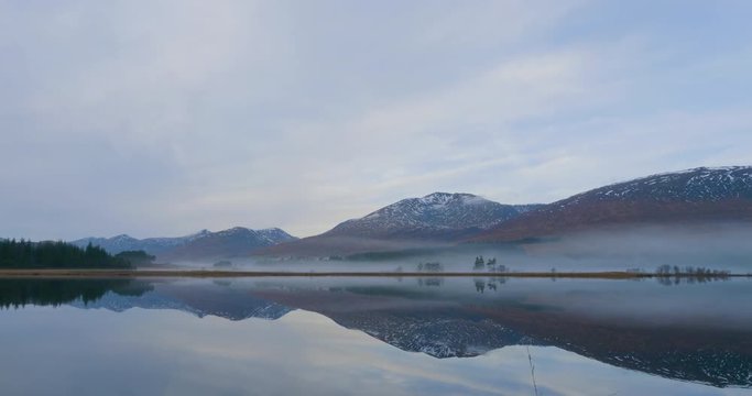 fog rolling in towards the mountains behind loch tulla in the highlands of scotland
