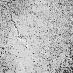 Concrete wall with cracked white clay coating