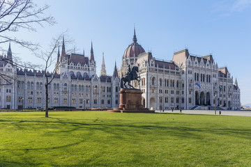 the beautiful Hungarian Parliament building on the background of green grass and blue sky