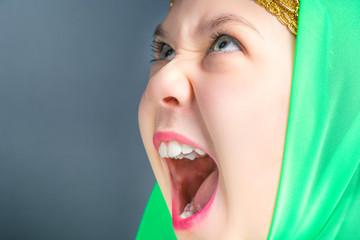 Cute little girl in green hijab for oriental dance with open mouth