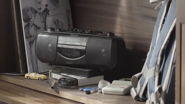 Dusty old radio with one cassette player with cassette tape. vintage cassette player background. Retro ghetto blaster cassette tape recorder on table