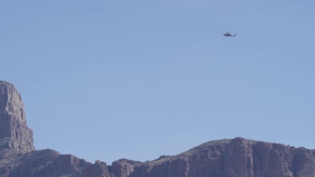 Apache helicopter travelling over mountains
